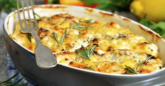 un gratin de courgettes avec du thym dessus et une fourchette